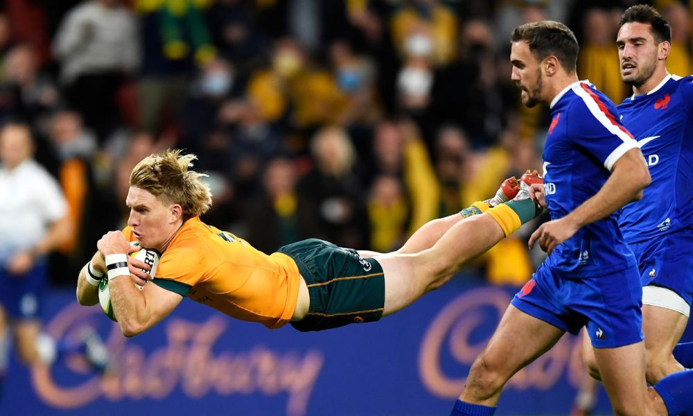 Australia's Jonathan Marmion dives to catch the ball during a game, showcasing his athleticism and determination.