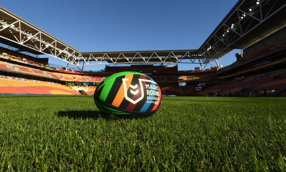 A magic round rugby ball on a grass pitch in a stadium