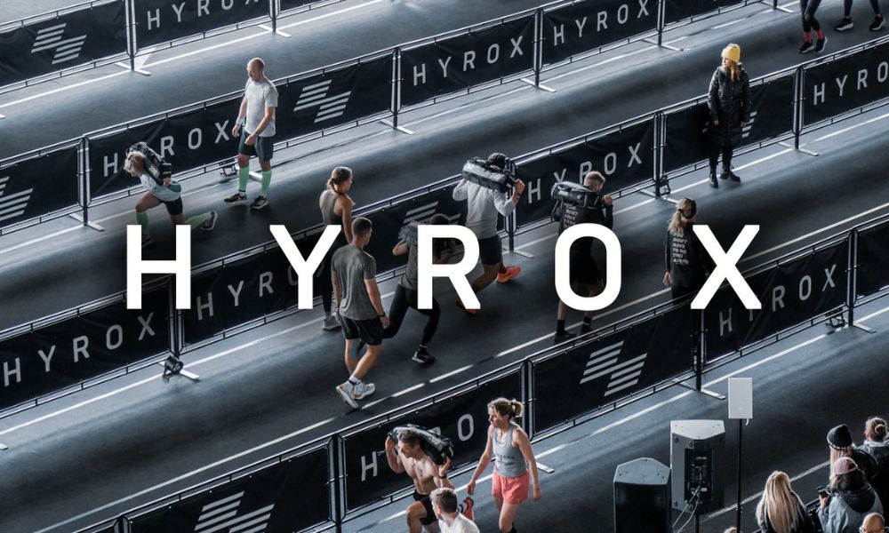 Ed Sheeran on stage playing guitar in front of an excited crowd.