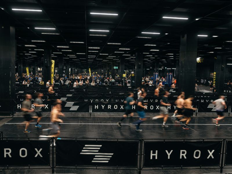 Hyrox Brisbane Athletes running in an indoor arena during a Hyrox competition with spectators watching on